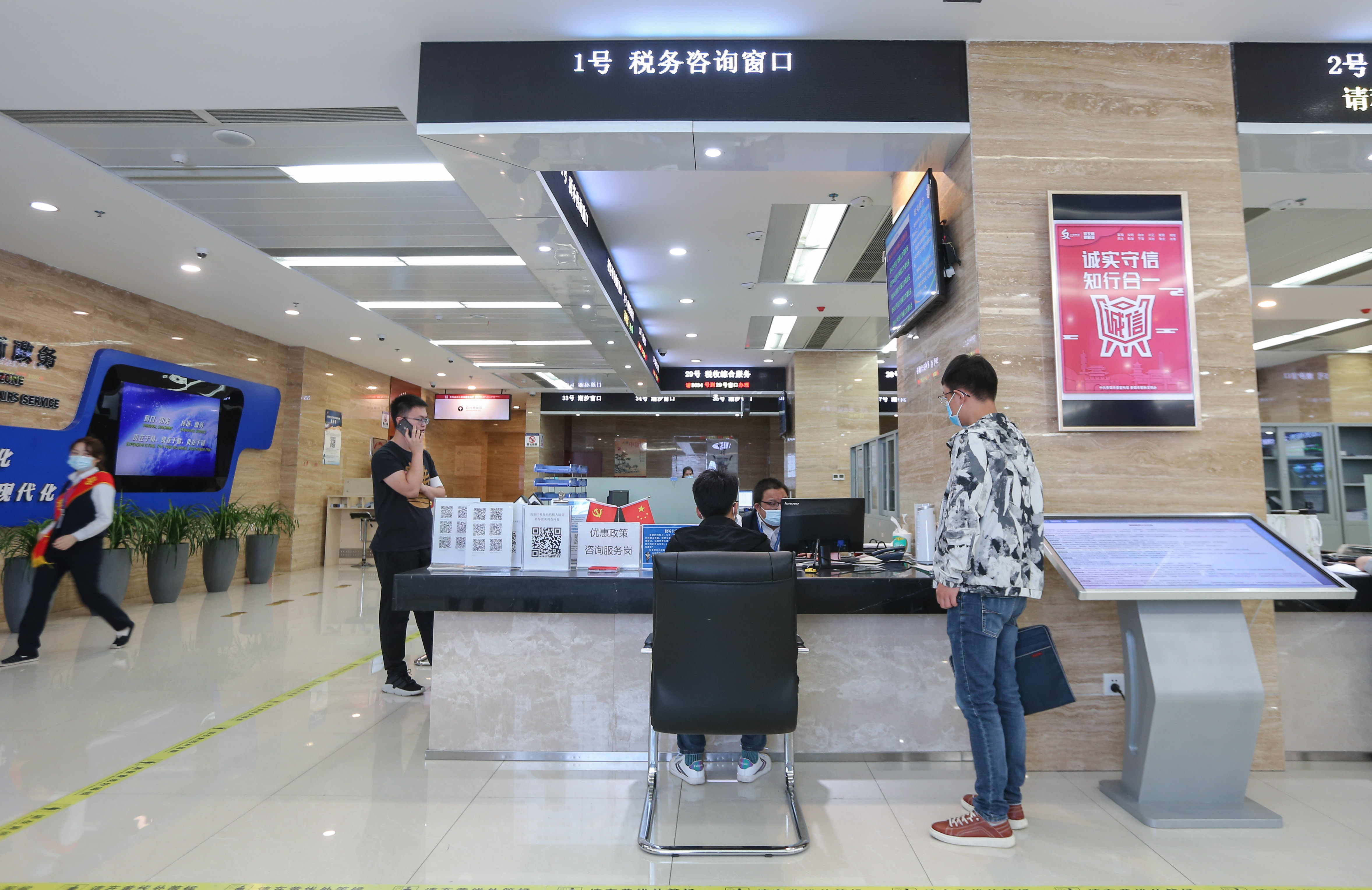 在高新区政务服务大厅1号税务咨询窗口,不间断的有市民询问个人,企业