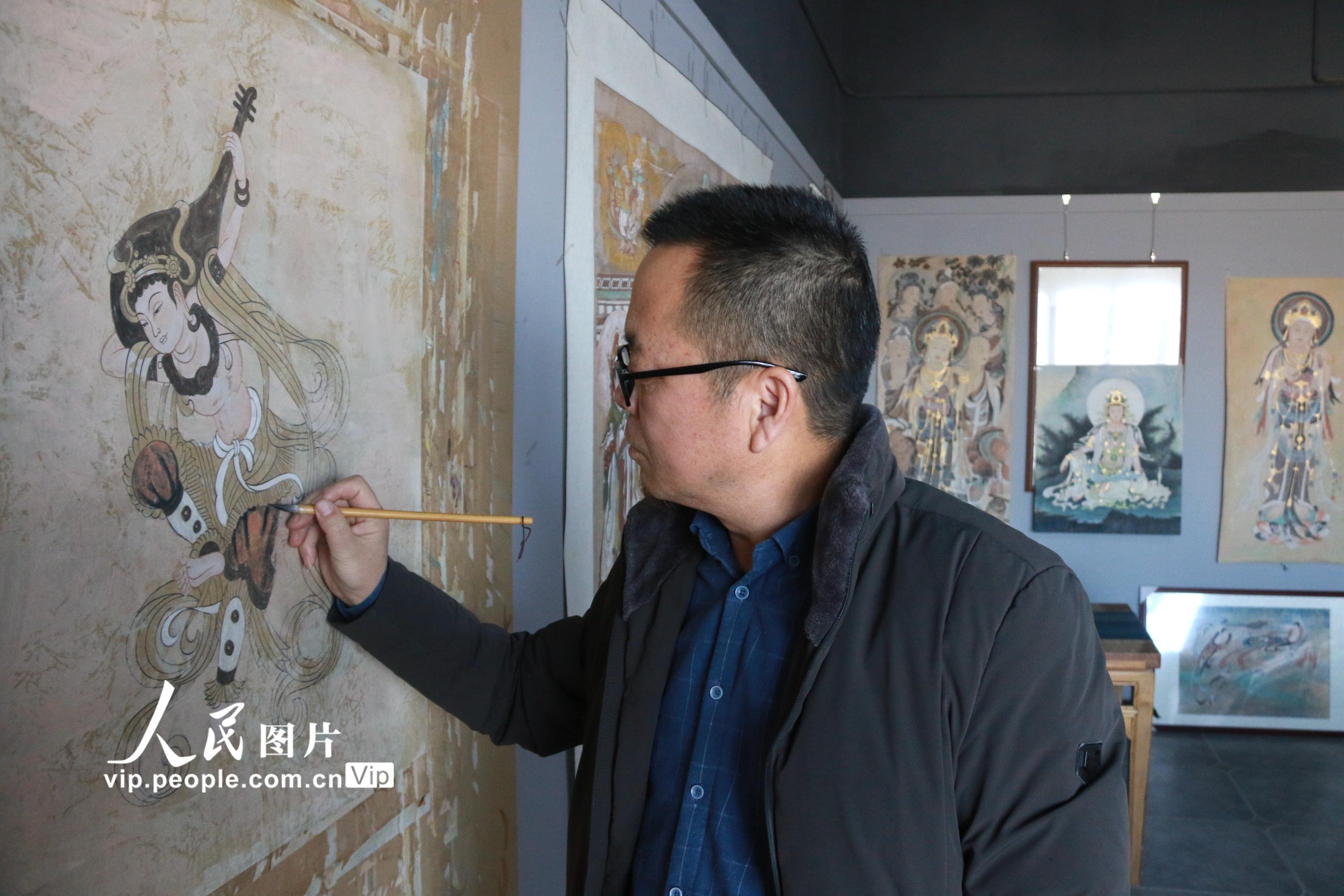 2020年12月10日,艺术工作者李永军在敦煌小镇鸣沙书院临摹敦煌壁画.