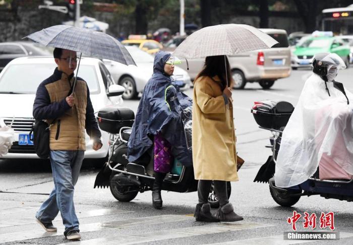 资料图：市民冒雨出行。 中新社记者 刘可耕 摄