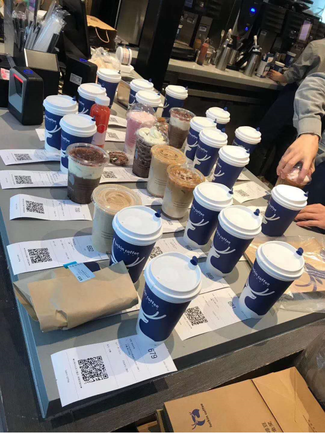 4月3日,瑞幸咖啡上海大华虎城店,前台摆满了制作好的外卖打包单.