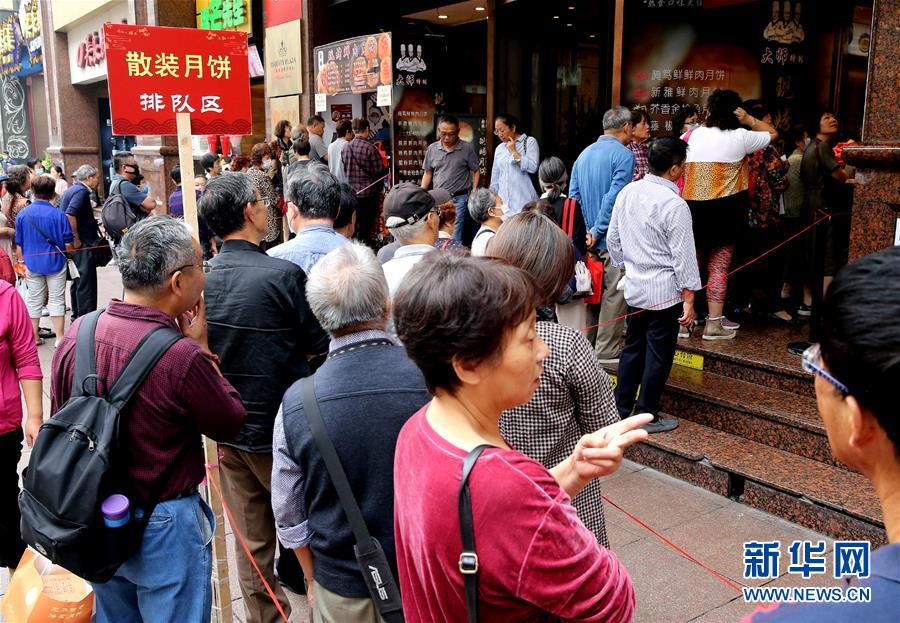 9月20日,顾客在上海南京路上排队购买现场制作的散装鲜肉月饼.