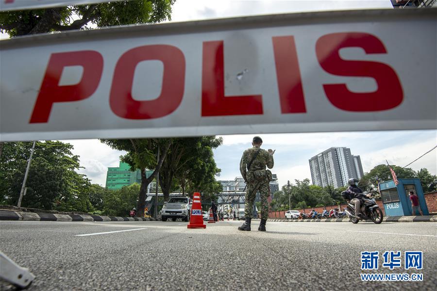 10月14日,警察和士兵在马来西亚吉隆坡的检查站检查过往车辆.