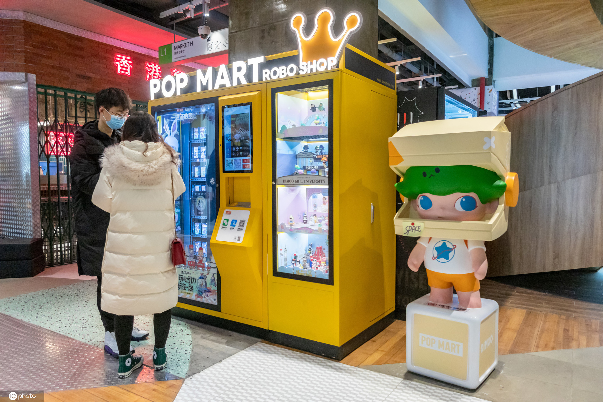 上海,淮海中路附近的商场内,一对情侣在一台popmart泡泡玛特售货机前