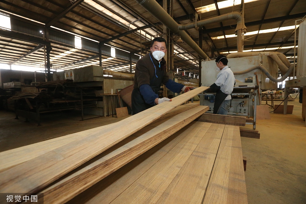 在四川眉山市洪雅竹元科技有限公司生产线,员工在搬运经热压后的竹钢